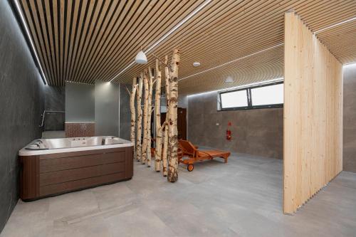 a bathroom with a tub and a sink and a bench at Brezovina Apartments Oravské Veselé - ORAVA in Veselé