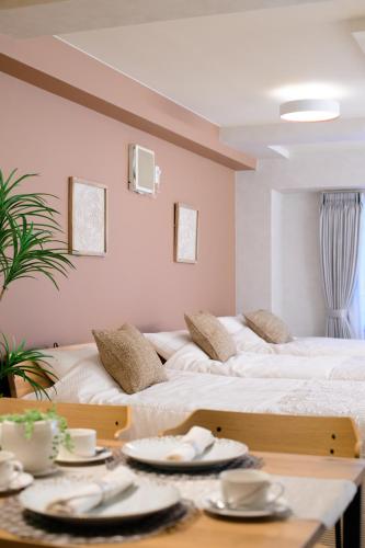 two beds in a room with plates on a table at Residence Stay Hanzomon - レジデンススティ半蔵門 in Tokyo