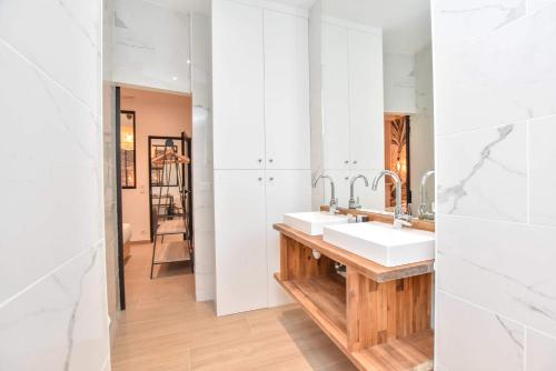 une salle de bain avec deux lavabos et un miroir dans l'établissement Charmant appartement Paris, à Paris