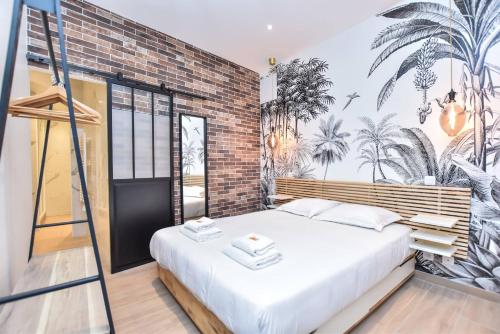 une chambre avec un lit et un mur de briques dans l'établissement Charmant appartement Paris, à Paris
