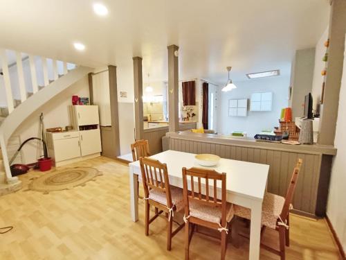 une cuisine et une salle à manger avec une table et des chaises blanches dans l'établissement Les Estives, T2 bis, centre Luchon, wifi, 6 personnes, à Luchon