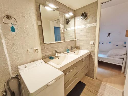 une salle de bain avec un lavabo et un miroir dans l'établissement Les Estives, T2 bis, centre Luchon, wifi, 6 personnes, à Luchon