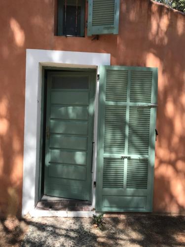 une porte verte et une fenêtre sur un bâtiment dans l'établissement Mini villa avec jardin, à Borgo