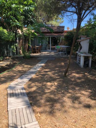 un jardin avec un chemin en bois menant à une maison dans l'établissement Mini villa avec jardin, à Borgo