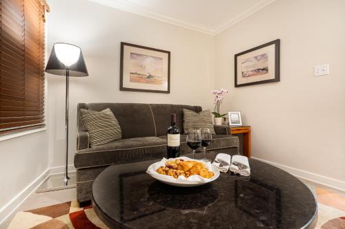 a living room with a couch and a table with wine glasses at Executive Suites Hotel & Conference Center, Metro Vancouver in Burnaby