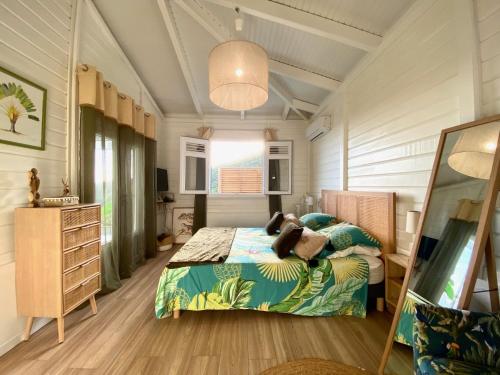a bedroom with a bed and a dresser at Villa Douceur Tropicale Sainte Luce vue mer in Sainte-Luce