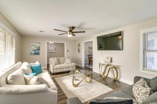 a living room with a couch and a ceiling fan at Home with Patio and Games Near Dtwn Pensacola! in Pensacola