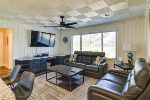 a living room with leather furniture and a ceiling fan at Home with Patio and Games Near Dtwn Pensacola! in Pensacola