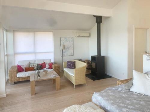 a living room with a couch and a table at Summerhouse With A View Of The Water in Skibby
