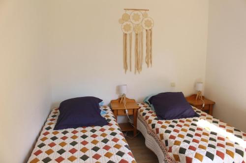 Cette chambre comprend 2 lits et 2 tables en bois. dans l'établissement Appartement T3 classé trois étoiles au calme de plain-pied au centre Doussard avec vue sur montagne, lac Annecy à proximité, à Doussard