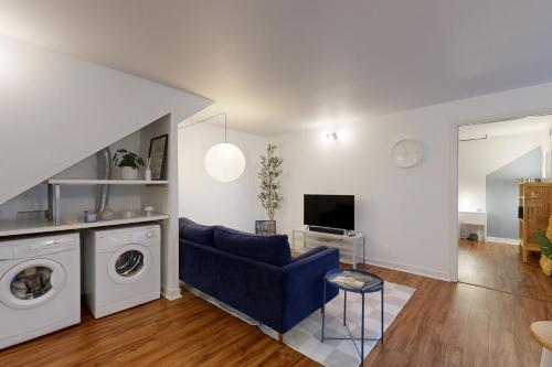 a living room with a blue couch and a washing machine at Portland Blues in Portland