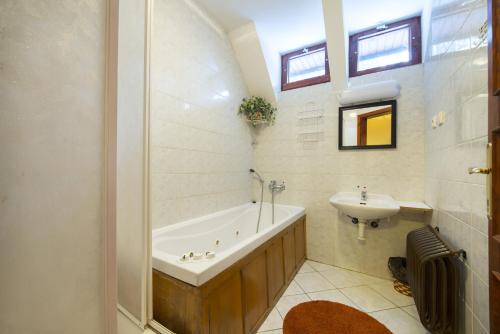 a bathroom with a bath tub and a sink at Chata Pleso in Tatranska Strba