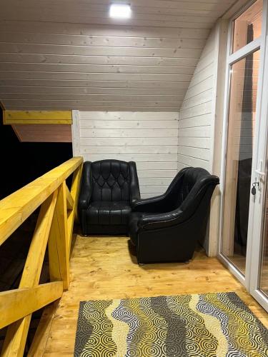 a black leather couch sitting in the corner of a room at Карпатська Модрина in Kosiv
