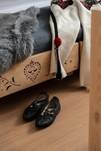 a pair of shoes sitting on the floor next to a bed at Panocek i Babka in Białka Tatrzanska