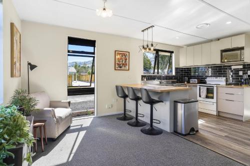 a kitchen with a counter and a table and a couch at Pet friendly holiday home and spa in sunny Cromwell in Cromwell