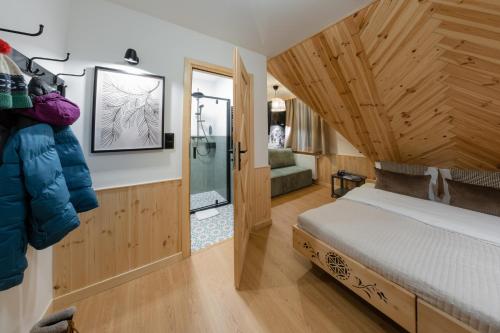 a bedroom with a bed in a room with wooden walls at Panocek i Babka in Białka Tatrzanska