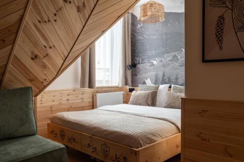a bedroom with a bed and a window and a chair at Panocek i Babka in Białka Tatrzanska