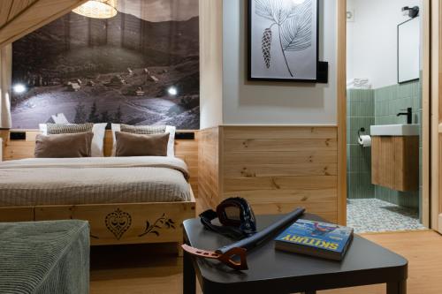 a bedroom with a bed and a table with a book at Panocek i Babka in Białka Tatrzanska