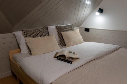 a bedroom with a bed with a book on it at Panocek i Babka in Białka Tatrzanska