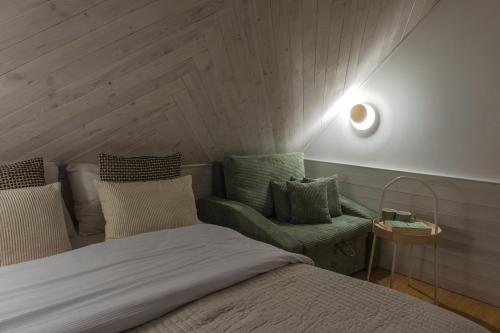 a bedroom with a bed and a green chair at Panocek i Babka in Białka Tatrzanska