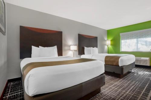 two beds in a hotel room with green walls at Quality Inn & Suites Birmingham - Highway 280 in Birmingham