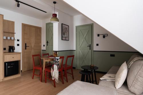 a living room with a couch and a table with chairs at Panocek i Babka in Białka Tatrzanska