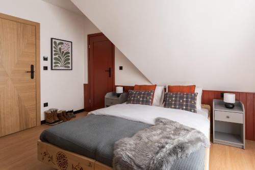 a bedroom with a large bed and a staircase at Panocek i Babka in Białka Tatrzanska