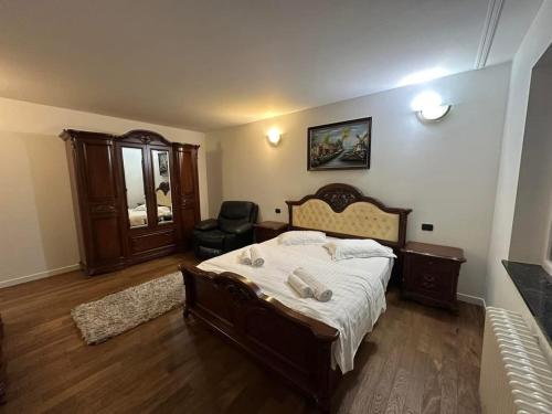 a bedroom with a large bed and a chair at Alex House in Borsa