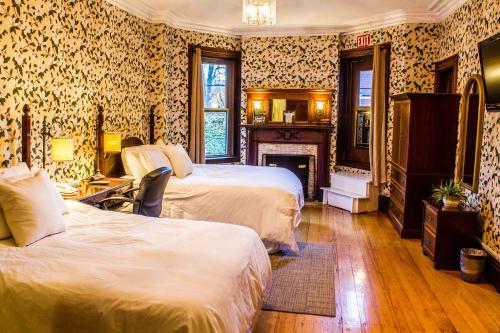 um quarto de hotel com duas camas e uma lareira em Beacon Inn 1087 em Brookline