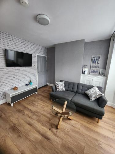 a living room with a couch and a tv at Manor House walsall 3 in Walsall
