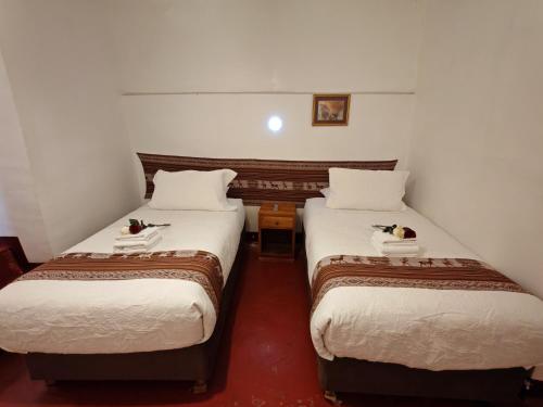 two beds in a hotel room with birds on them at Afma Cusco in Cusco