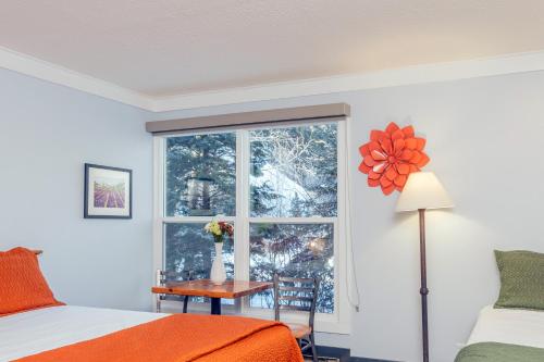 a bedroom with a window and a bed and a table at Mountainside Inn 103 by Alpine Lodging Telluride in Telluride
