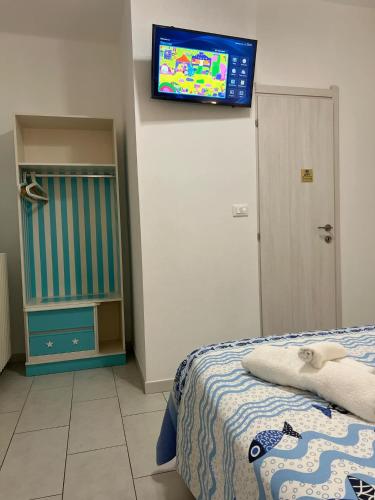 a bedroom with a bed and a television on the wall at Bike Hotel Oasi in Finale Ligure