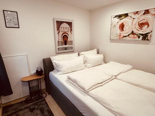 Schlafzimmer mit einem Bett mit weißer Bettwäsche und einem Tisch in der Unterkunft COY Apartments Kaltenleutgeben - Nature Meets Style in Kaltenleutgeben