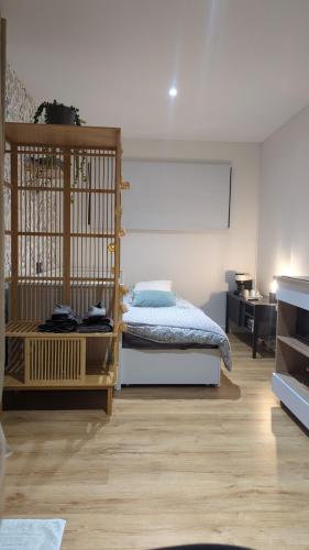 une chambre avec un lit et un bureau dans une pièce dans l'établissement Jupiter Tiny House, à Nanteuil-lès-Meaux