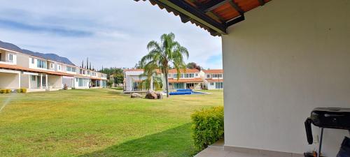 a view of a yard with palm trees and houses at Riberas del Chante, casa de descanso in Jocotepec