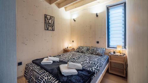 a bedroom with a bed with two towels on it at Muchatki domki z sauną in Zagórze