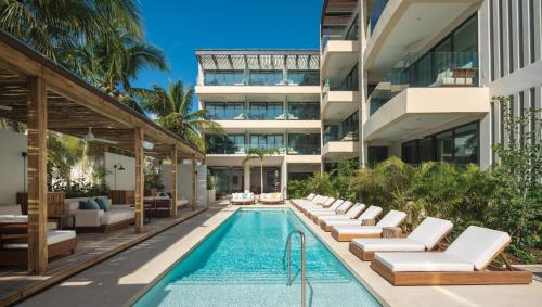 an exterior view of a building with a swimming pool at Hyatt Centric Playa del Carmen - Downtown House & Beach House in Playa del Carmen
