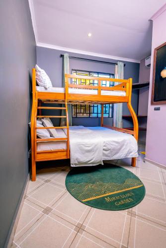 a bedroom with two bunk beds and a green rug at Swahili Homes- Ada Estate in Dar es Salaam