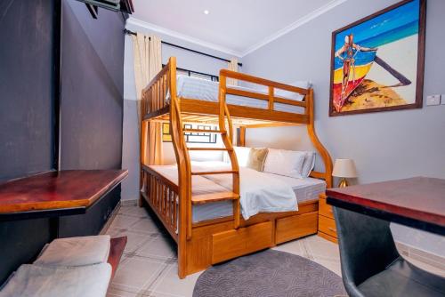 a bedroom with two bunk beds and a desk at Swahili Homes- Ada Estate in Dar es Salaam