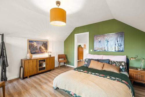 a bedroom with a bed and a green wall at Press4Living Cottage near Vienna in Ebenthal