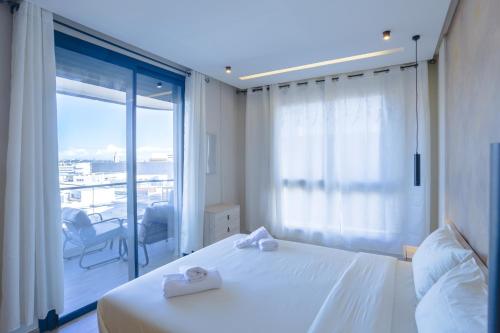 a bedroom with a white bed and a large window at Résidence Tour 33 - CFC district in Casablanca