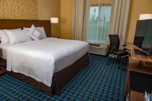 a hotel room with a bed and a desk and a television at Fairfield Inn & Suites by Marriott Anderson in Anderson