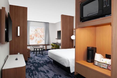 a hotel room with a bed and a flat screen tv at Fairfield Inn & Suites by Marriott Fort Morgan in Fort Morgan
