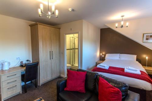 1 dormitorio con cama, escritorio y silla en The Douglas Hotel, en Hartlepool