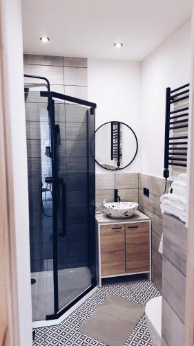 a bathroom with a glass shower and a sink at GóralSki in Wisła