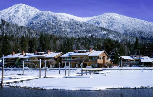 a resort in the snow with mountains in the background at Pend Oreille Shores Resort in Hope