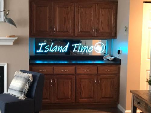 a living room with a tv with a island time sign at On Island Time at Kelleys Island Condo! in Kelleys Island