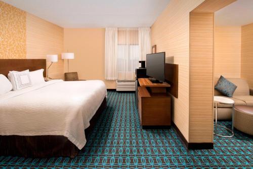 a hotel room with a large bed and a chair at Fairfield Inn & Suites by Marriott Albany East Greenbush in East Greenbush