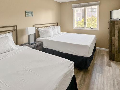 a bedroom with two beds and a window at On Island Time at Kelleys Island Condo! in Kelleys Island